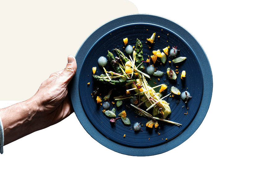 Main présantant une assiette contenant un plat